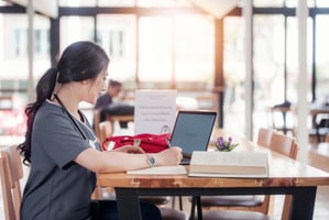 Nurse Working On A Computer In Coffee Shop
