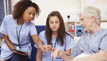 Nurses Working Together to Help Elderly Patient